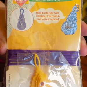May include: A yellow plastic template for making a tear drop knot. The package includes instructions, trial cords, and the template. The package is labeled "Asian Knot Tear Drop Knot" and "Clover Art No. 8502".