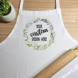 May include: White apron with a green floral wreath design and the text "Your custom design here".