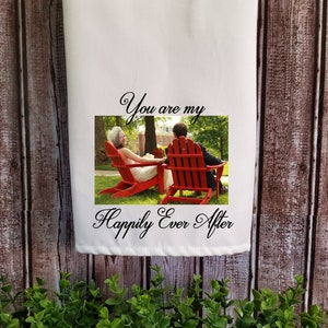 May include: A white tea towel with a photo of a couple sitting on red chairs in a grassy area. The text "You are my Happily Ever After" is printed on the towel.