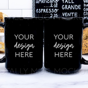 May include: Two black coffee mugs with white text that says "YOUR design HERE". The mugs are on a white marble surface with biscotti cookies in the background.