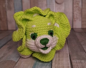 May include: A crocheted stuffed animal in the shape of a lion with green and white fur. The lion has a white face with green eyes and a green nose.