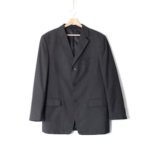 May include: A dark grey blazer with a three-button closure and a single vent at the back.
