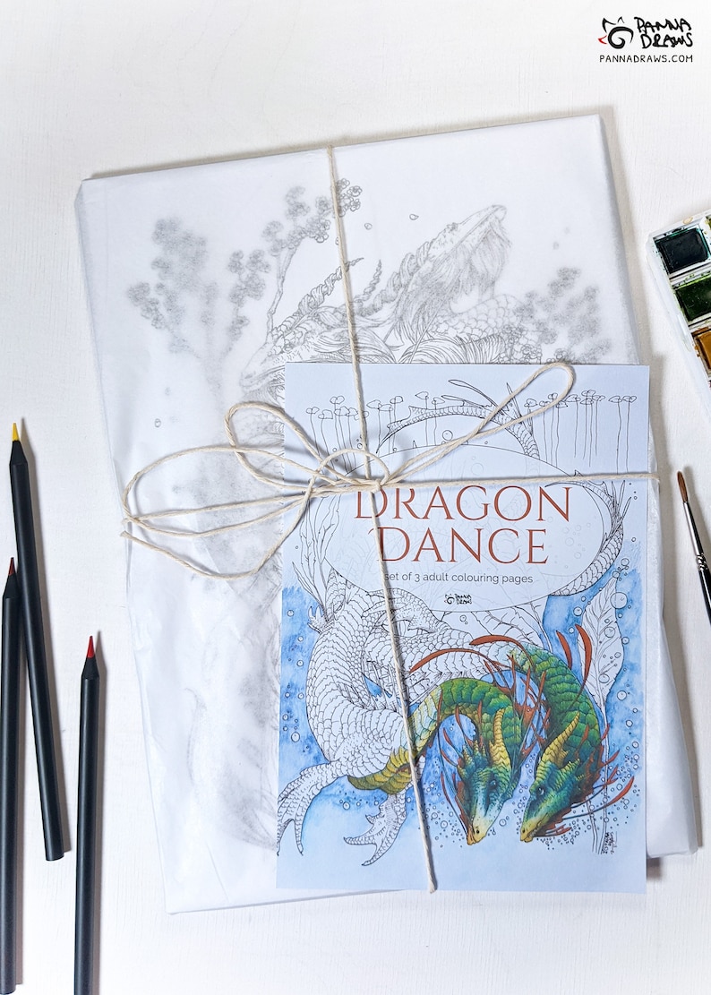 May include: A set of three adult coloring pages featuring a dragon dance. The cover shows two dragons, one green and one white, intertwined in a dance. The title "Dragon Dance" is printed in white on a blue background. The text "Set of 3 adult colouring pages" is printed below the title.