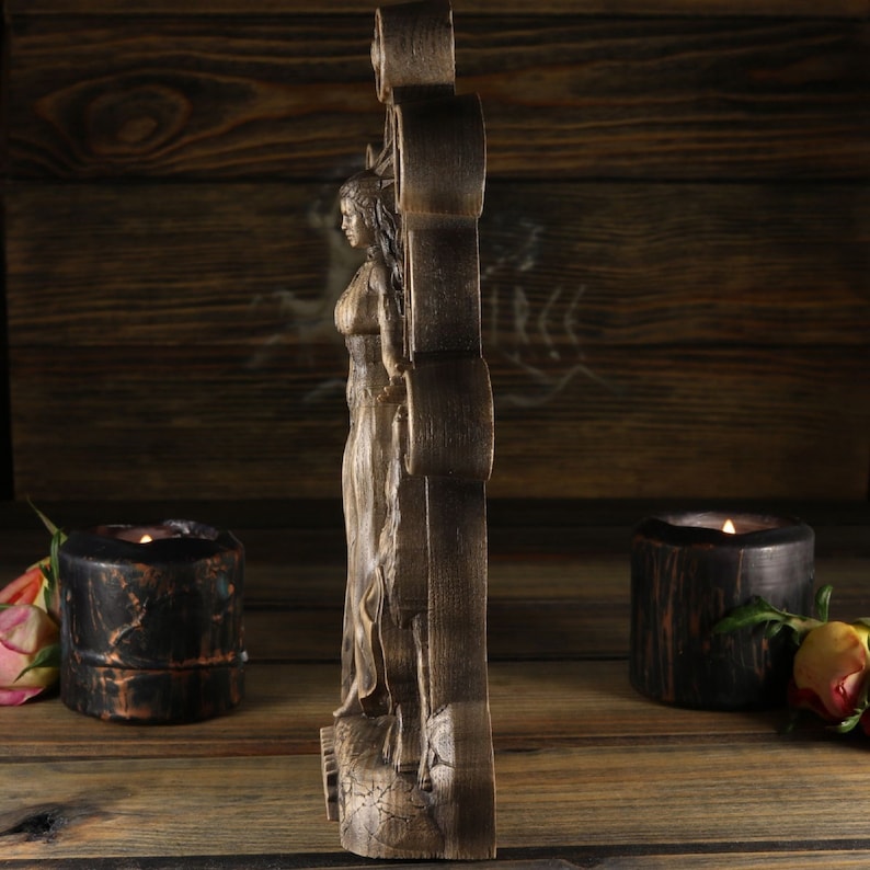 May include: A wooden wall sculpture featuring a carved female figure with flowing hair and a long dress. The sculpture is painted in shades of brown and has a detailed design.