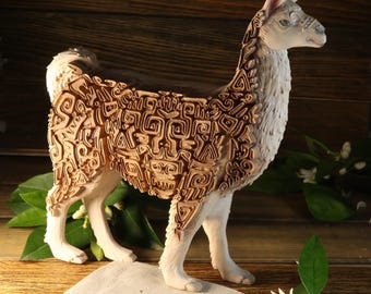 Könnte beinhalten: Eine weiße Keramik-Lama-Figur mit braunem Muster. Das Lama steht auf einer weißen Oberfläche mit einem Holz Hintergrund.