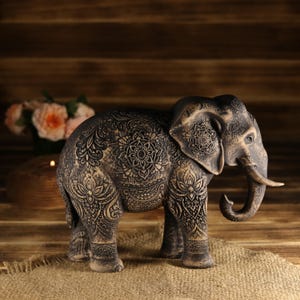 Sacred luck wood art of an elephant standing on an old wooden surface, atmospheric studio lighting shot.
