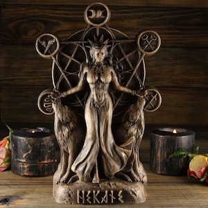 May include: A wooden statue of the Greek goddess Hekate, depicted with a crown, flowing robes, and two wolves. The statue is set against a wooden background and features a geometric design with symbols.