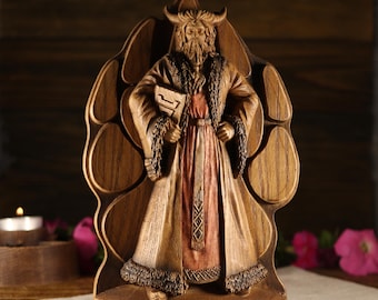 May include: Wooden sculpture of the Slavic god Veles, depicted as a bearded man with horns, holding a scroll. The sculpture is carved in a detailed style and features a brown wood finish. The base of the sculpture is inscribed with the word "VELES".