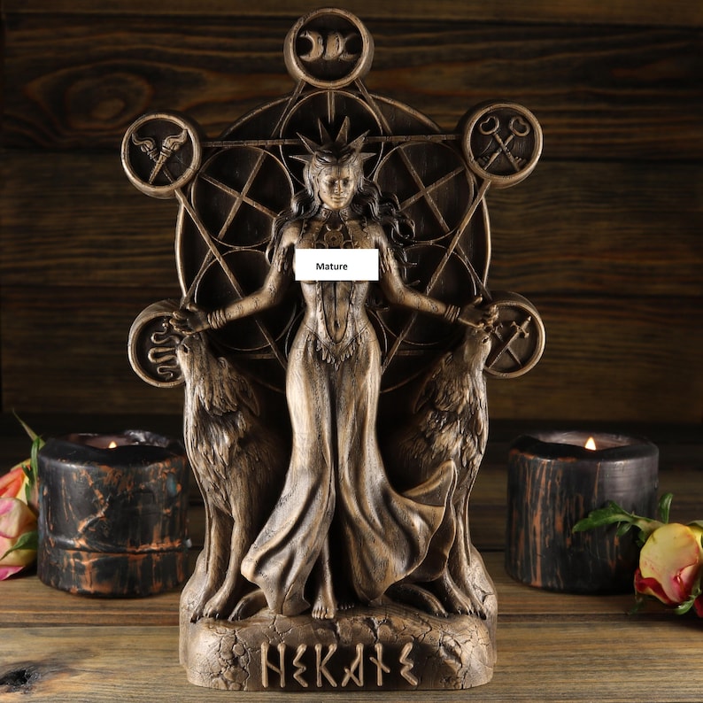 May include: A bronze statue of the Greek goddess Hekate, standing with two wolves at her side. She is depicted with a crown and a flowing robe, and is surrounded by a pentagram and other symbols. The statue is inscribed with the word "Hekate" in Greek letters.