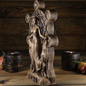 May include: A wooden wall sculpture depicting a woman standing with a wolf. The woman is wearing a long dress and has long hair. The sculpture is carved with intricate details and features a pentagram design.