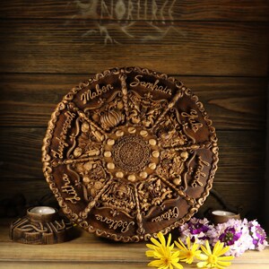 Peut inclure: Une roue de l'ann&eacute;e en bois avec des sculptures de chacune des huit sabbats. La roue est brune et a une finition en bois naturel. Les sabbats sont &eacute;tiquet&eacute;s dans le sens des aiguilles d'une montre&nbsp;: Yule, Imbolc, Ostara, Beltane, Litha, Lammas, Mabon et Samhain.