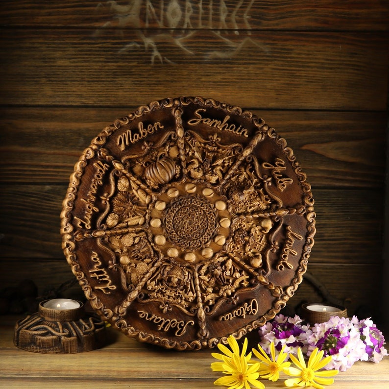 Peut inclure: Une roue de l'ann&eacute;e en bois avec des sculptures de chacune des huit sabbats. La roue est brune et a une finition en bois naturel. Les sabbats sont &eacute;tiquet&eacute;s dans le sens des aiguilles d'une montre&nbsp;: Yule, Imbolc, Ostara, Beltane, Litha, Lammas, Mabon et Samhain.