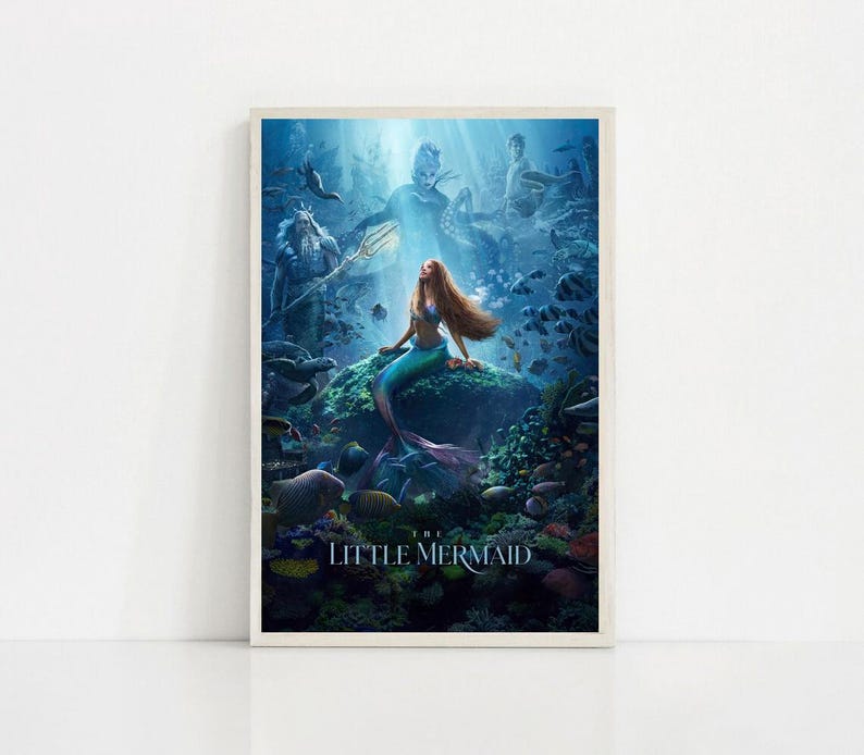 Puede incluir: Un p&oacute;ster enmarcado que presenta una sirena con largo cabello rojo y una cola turquesa, sentada en una roca bajo el agua. El p&oacute;ster tiene una combinaci&oacute;n de colores azul y verde, con las palabras "THE LITTLE MERMAID" en la parte inferior.