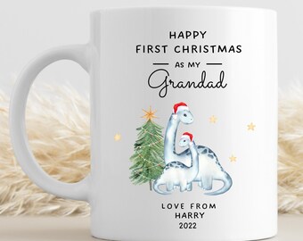 Può includere: Tazza in ceramica bianca con un design natalizio con due dinosauri che indossano cappelli di Babbo Natale. Il testo recita "Buon primo Natale come mio nonno. Con affetto da Harry 2022."