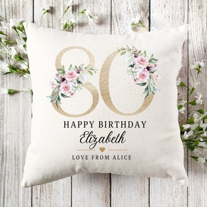 May include: A white cushion with a gold 80 surrounded by pink and white flowers. The text "Happy Birthday Elizabeth Love from Alice" is printed below the number.