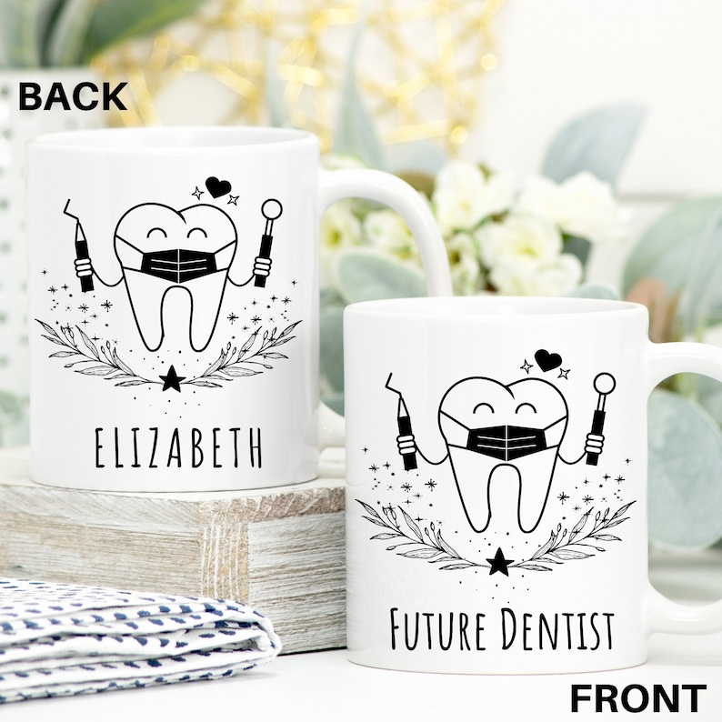 May include: White ceramic mug with a black and white illustration of a tooth wearing a face mask and holding dental tools. The text "FUTURE DENTIST" is printed on the front of the mug.
