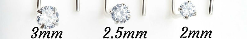 May include: Three silver earring studs with clear round stones. The stones are 3mm, 2.5mm, and 2mm in diameter.