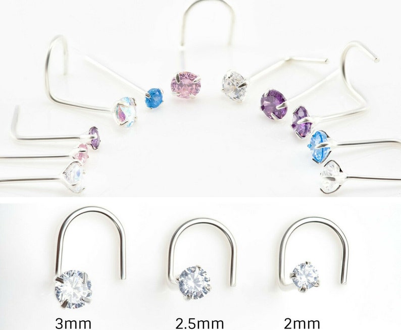 May include: A set of nose rings with different colored gemstones. The rings are made of silver and have a curved shape. The gemstones are available in sizes 2mm, 2.5mm, and 3mm.