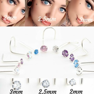 May include: A set of nose rings with different coloured gemstones. The rings are available in 2mm, 2.5mm, and 3mm sizes. The gemstones are clear, pink, blue, and purple.