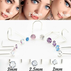 May include: A set of nose rings with different colored gemstones. The rings are available in 2mm, 2.5mm, and 3mm sizes. The gemstones are clear, pink, blue, and purple.