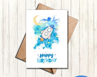 May include: Printable 5x7 card featuring a watercolor illustration of a rocket ship flying through a blue and yellow galaxy with stars and a crescent moon. The text "Happy Birthday" is written below the rocket ship.