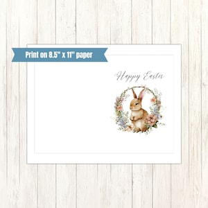 May include: A printable card with a watercolor illustration of a brown bunny rabbit sitting inside a floral wreath. The text "Happy Easter" is written in cursive above the wreath.
