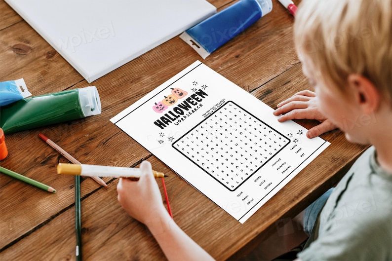 May include: A black and white Halloween word search puzzle with a grid of letters and a list of words to find. The puzzle features a graphic of three orange pumpkins with black eyes and mouths.