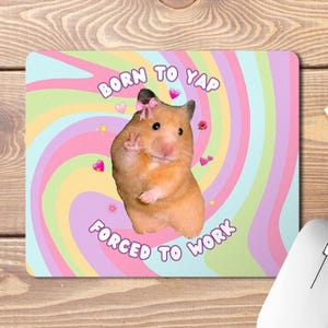 May include: A pink, yellow and blue swirl background with a hamster wearing a pink bow. The text "Born to Yap Forced to Work" is written on the background.