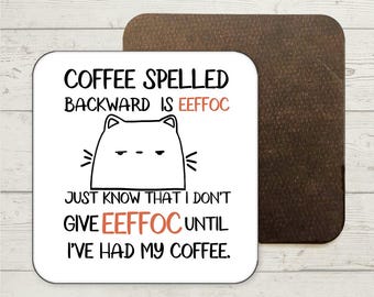 Puede incluir: Posavasos blanco con texto negro y naranja que dice "COFFEE SPELLED BACKWARD IS EEFFOC JUST KNOW THAT I DON'T GIVE EEFFOC UNTIL I'VE HAD MY COFFEE." Un gato de dibujos animados en blanco y negro está sobre el texto.