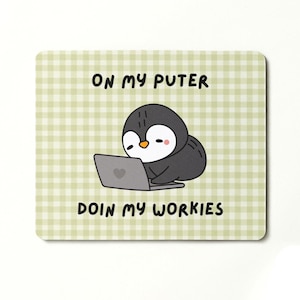 May include: A square mouse mat with a light green and white gingham pattern. The mat features a cartoon penguin working on a laptop with the text "ON MY PUTER DOIN MY WORKIES". The penguin is black, white, and has a pink blush.