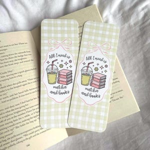 Op de afbeelding: Twee rechthoekige bladwijzers met een lichtgroen ruitpatroon. Elke bladwijzer heeft een afbeelding van een matcha-drankje, boeken en de tekst "All I need is matcha and books" in een roze kader.