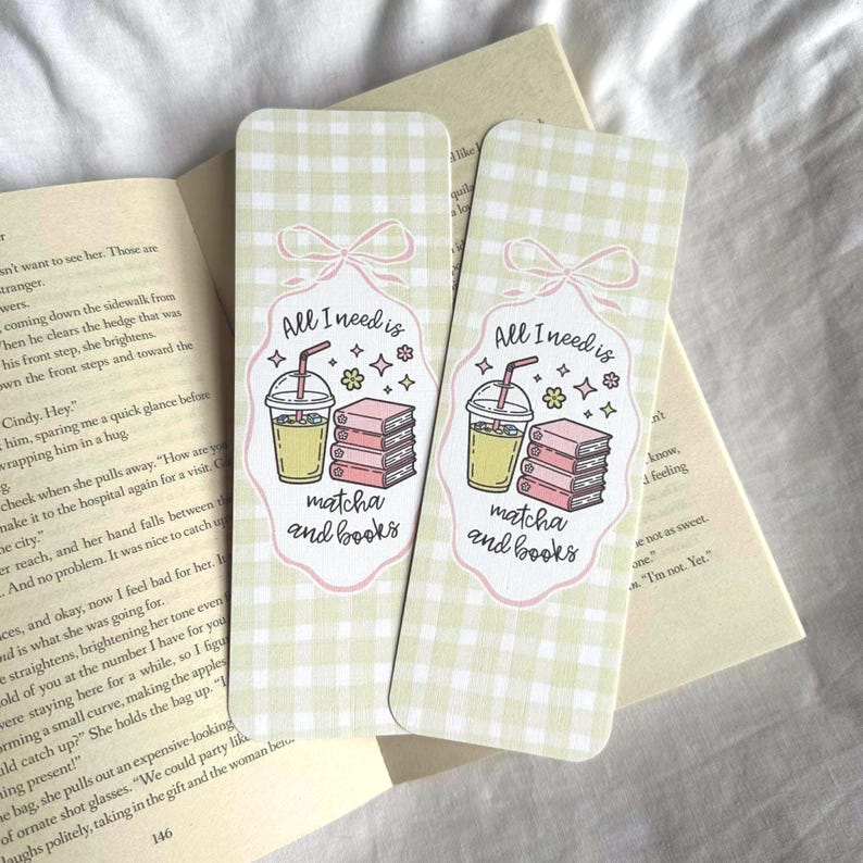 Op de afbeelding: Twee rechthoekige bladwijzers met een lichtgroen ruitpatroon. Elke bladwijzer heeft een afbeelding van een matcha-drankje, boeken en de tekst "All I need is matcha and books" in een roze kader.