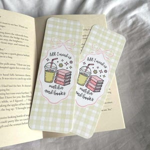 May include: Two rectangular bookmarks with a light green gingham pattern. Each bookmark features a cartoon illustration of a matcha drink, books, and the text "All I need is matcha and books."