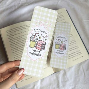 Op de afbeelding: Twee rechthoekige bladwijzers met een lichtgroen ruitpatroon. Elke bladwijzer heeft een roze en wit label met de tekst "All I need is matcha and books" en illustraties van matcha en boeken.