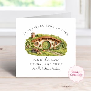 May include: A square greeting card featuring a watercolor illustration of a round-doored earth-sheltered house with a green door, stone chimney, and garden. Text reads: CONGRATULATIONS ON YOUR new home HANNAH AND CHRIS 33 Hobiton Way.
