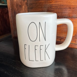 May include: White ceramic mug with black text that reads "ON FLEEK".