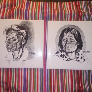 May include: Two black and white portrait illustrations of people on white ceramic tiles. The first tile features a man with short, gray hair and the text "James Smith, Labrador, June 24, 1913". The second tile features a woman with long, dark hair and the text "Esther Williams, Thule, Alaska, June 14, 1913".