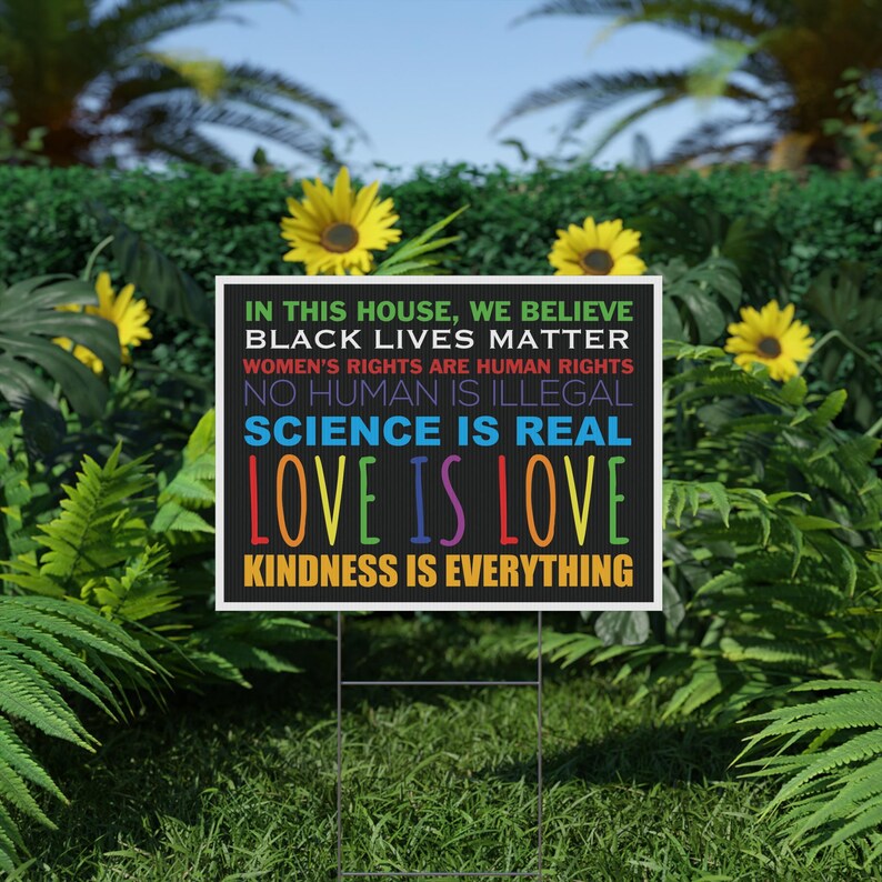 Puede incluir: Un letrero de jard&iacute;n rectangular negro con borde blanco que presenta el texto: IN THIS HOUSE, WE BELIEVE, BLACK LIVES MATTER, WOMEN'S RIGHTS ARE HUMAN RIGHTS, NO HUMAN IS ILLEGAL, SCIENCE IS REAL, LOVE IS LOVE, y KINDNESS IS EVERYTHING.