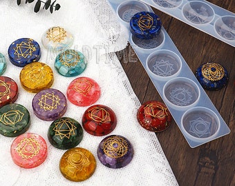 May include: Colorful resin chakra stones with gold-colored symbols and inclusions. The stones are in various colors, including blue, red, green, and yellow. A clear silicone mold with circular cavities is also visible.