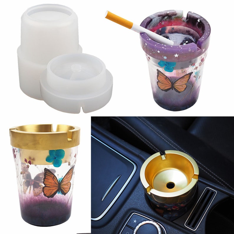 Puede incluir: Una colecci&oacute;n de ceniceros en varios dise&ntilde;os. Uno es un molde transparente, otro es una taza morada con un dise&ntilde;o de mariposa, y un tercero es una taza con borde dorado con un dise&ntilde;o de mariposa. El &uacute;ltimo cenicero es dorado y cabe en un portavasos de coche.