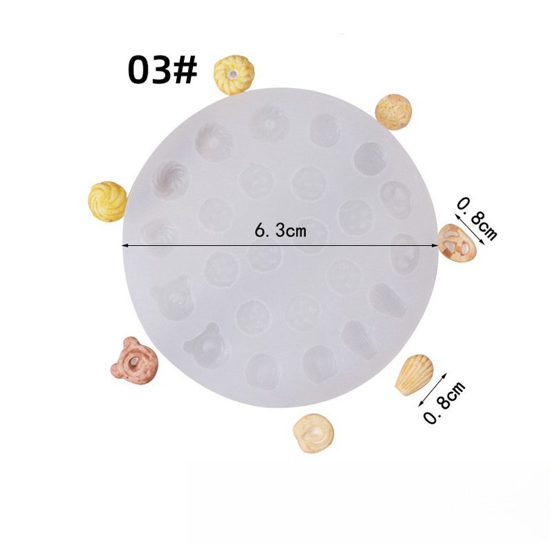 May include: A clear silicone mold with various shapes, including circles, bears, and shells. The mold is 6.3 cm in diameter and has several small, finished resin pieces around it. The text "03#" is in the upper left corner.