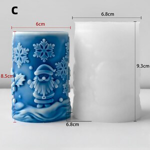 May include: A blue candle featuring a Santa Claus design and snowflake details. The candle measures 8.5 cm high and 6 cm wide. Beside it is a white silicone mould, 9.3 cm high and 6.8 cm wide, for candle making. The letter "C" is in the top left.