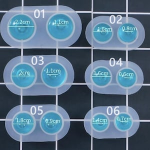 May include: A clear silicone mold with six sets of two circular cavities. Each set is labeled with a number and has measurements in centimeters. The cavities are filled with a light blue resin. The largest cavity is 2.2cm.