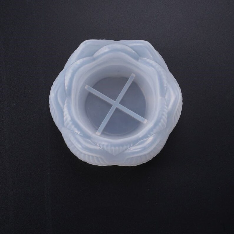 Puede incluir: Un molde de silicona azul claro con forma de flor para manualidades. El molde presenta un dise&ntilde;o detallado de p&eacute;talos y una estructura de soporte en forma de cruz en el interior. Ideal para arte con resina o fabricaci&oacute;n de velas.