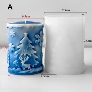 May include: A blue Christmas candle featuring a tree, snowflakes, and a deer design. The candle is 6.5 cm wide and 8.3 cm tall. A white candle mould is next to it, measuring 7.5 cm wide and 9.5 cm tall.