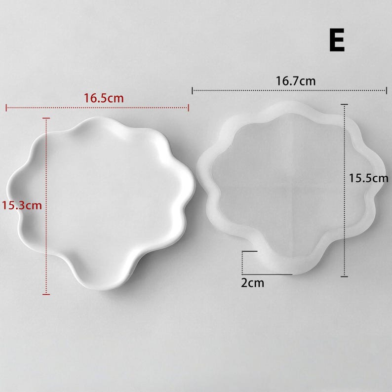 May include: Two white, wavy-edged plates. One plate measures 6.5 inches by 6 inches. The other plate is a clear, wavy-edged mold, measuring 6.6 inches by 6.1 inches, with a 0.8-inch depth. The letter "E" is in the upper right corner.