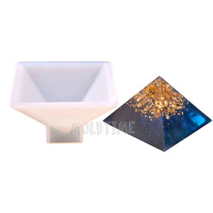May include: A white silicone pyramid mold and a finished resin pyramid with gold leaf accents. The resin pyramid has a dark blue and black base. The text "MOLDTIME" is visible on the mold.