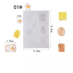 May include: A silicone mold with various food shapes, including eggs, cheese, and toast, alongside finished resin pieces. The mold measures 6.3 cm x 4.3 cm. The text "01#" is visible in the upper left corner. The finished pieces are approximately 1.9 cm x 1 cm.