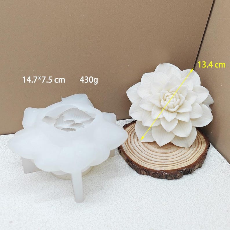 May include: A white, flower-shaped silicone mold next to a finished white flower. The mold measures 14.7 x 7.5 cm and weighs 430g. The finished flower is 13.4 cm in diameter and sits on a wooden slice. Ideal for crafting.