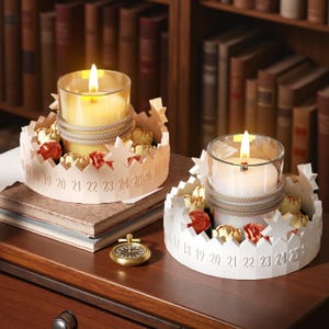 May include: Two lit candles in glass holders, each surrounded by a white, star-shaped paper ring with numbers 17-27. The candles are decorated with rope and small floral accents. A gold pocket watch sits nearby.